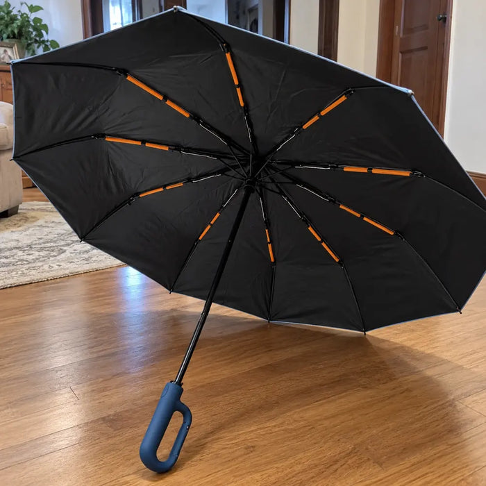 Photo d'un client : parapluie Nuvya StormHook ouvert sur un parquet, poignée bleu