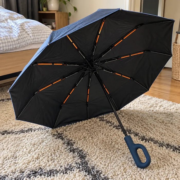 Photo d'un client : parapluie Nuvya StormHook ouvert sur un tapis, poignée bleu marine